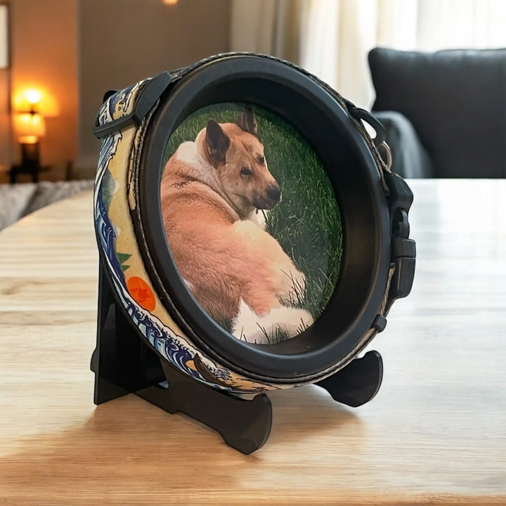 Round pet memorial frame with tan and blue artistic collar, displaying dog laying in the grass in a peaceful pose