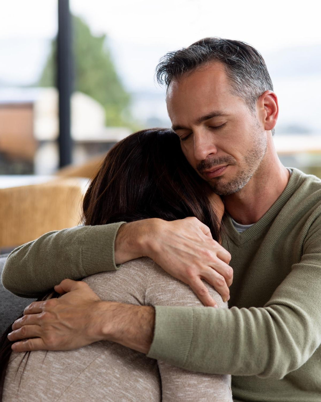 Person comforting a grieving friend after the loss of a beloved dog in a warm and supportive setting